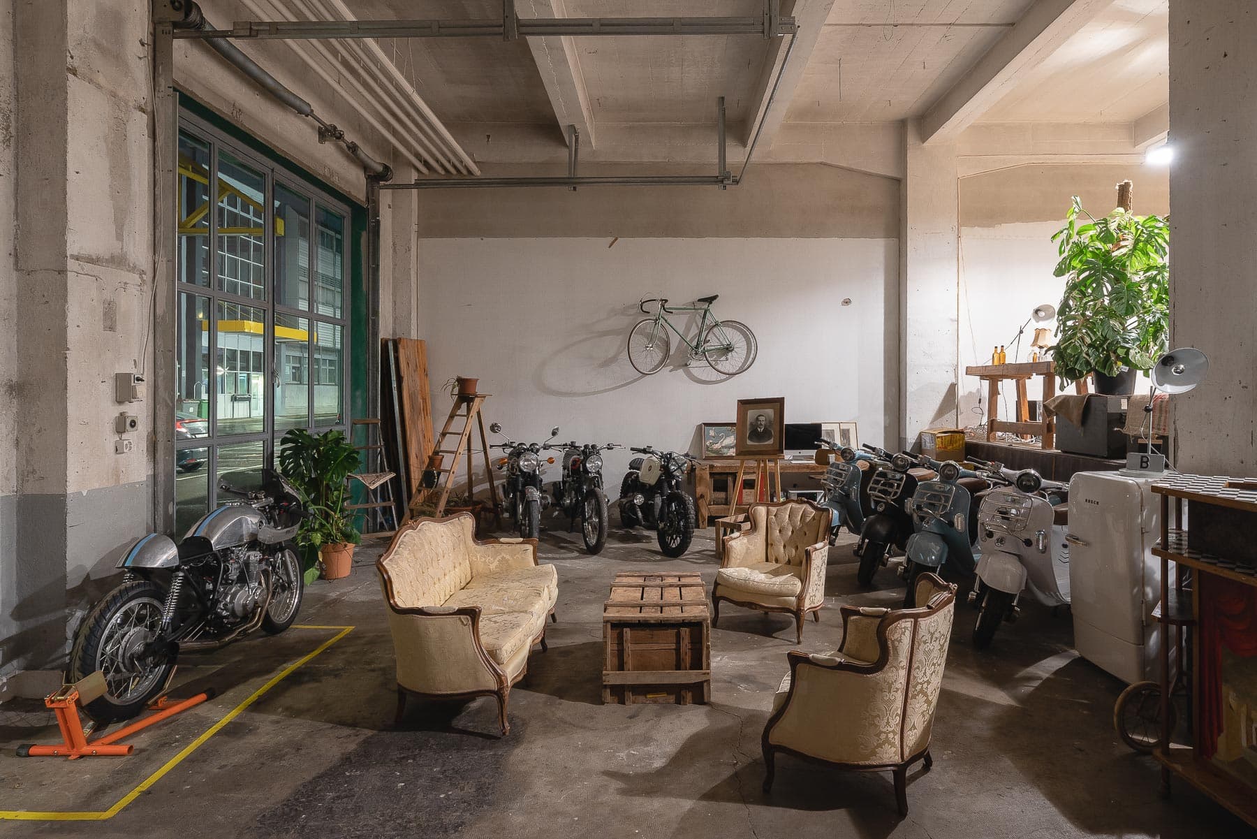 Intérieur d'entrepôt de 240m² mettant en valeur la lumière naturelle à travers de grandes fenêtres, plafond industriel exposé et espace ouvert polyvalent parfait pour événements privés, expositions et célébrations à Lausanne